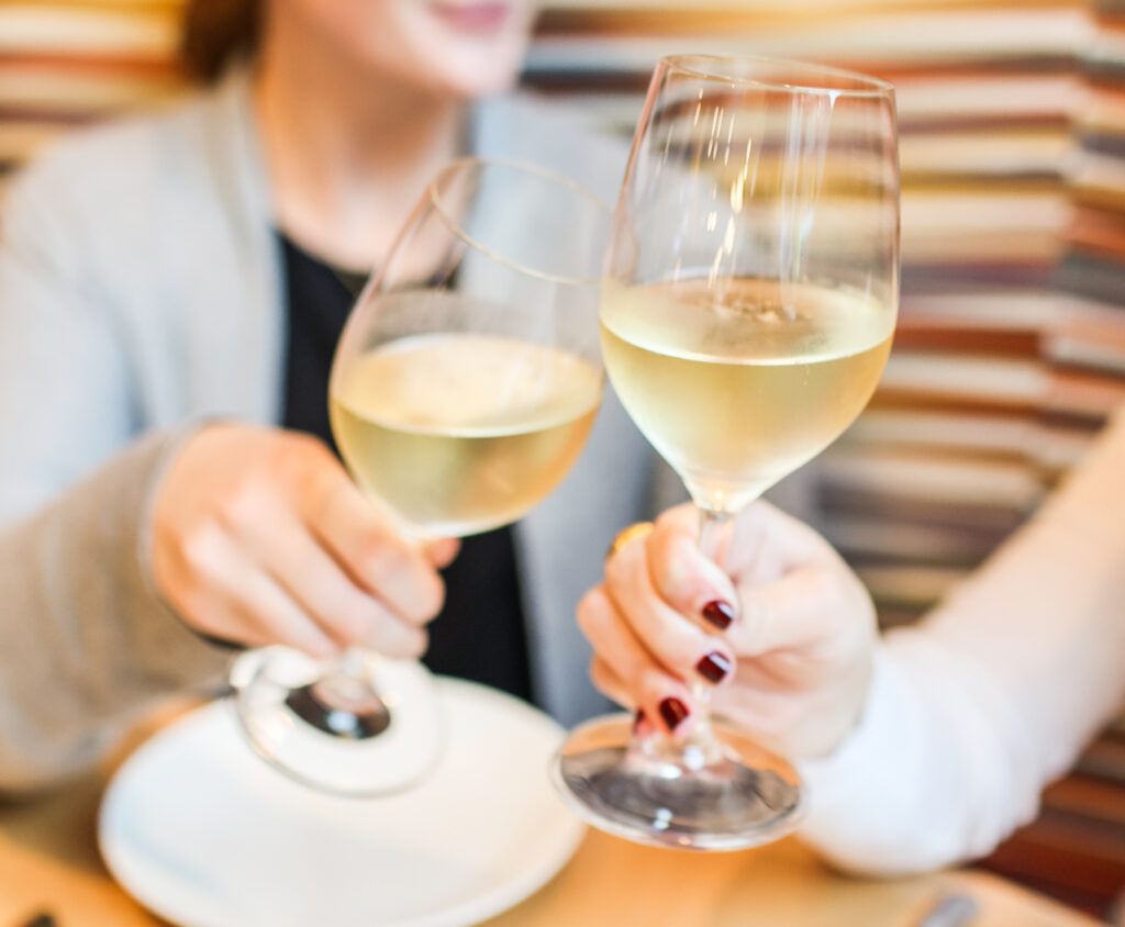 Two people making a cheers with wine glasses